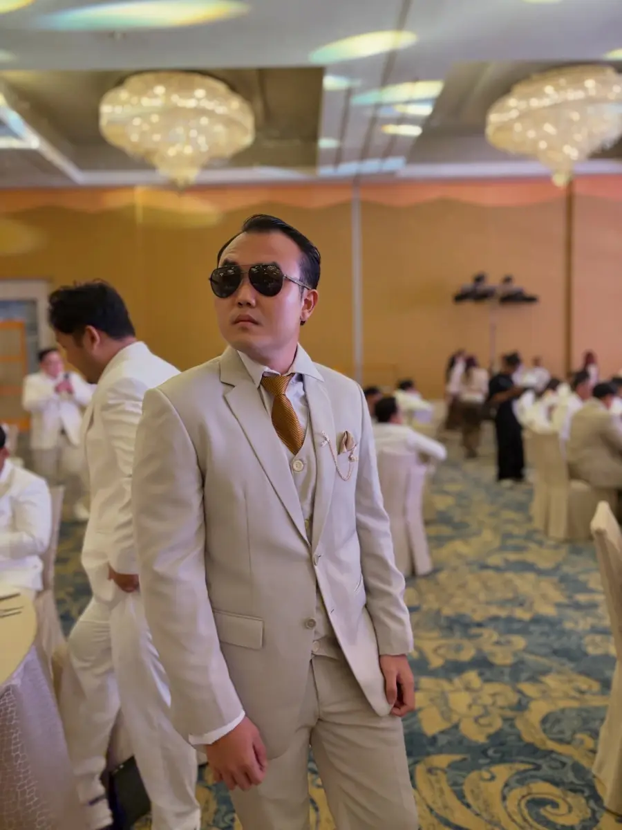 Ko Evans memakai jas krem dan kacamata hitam
